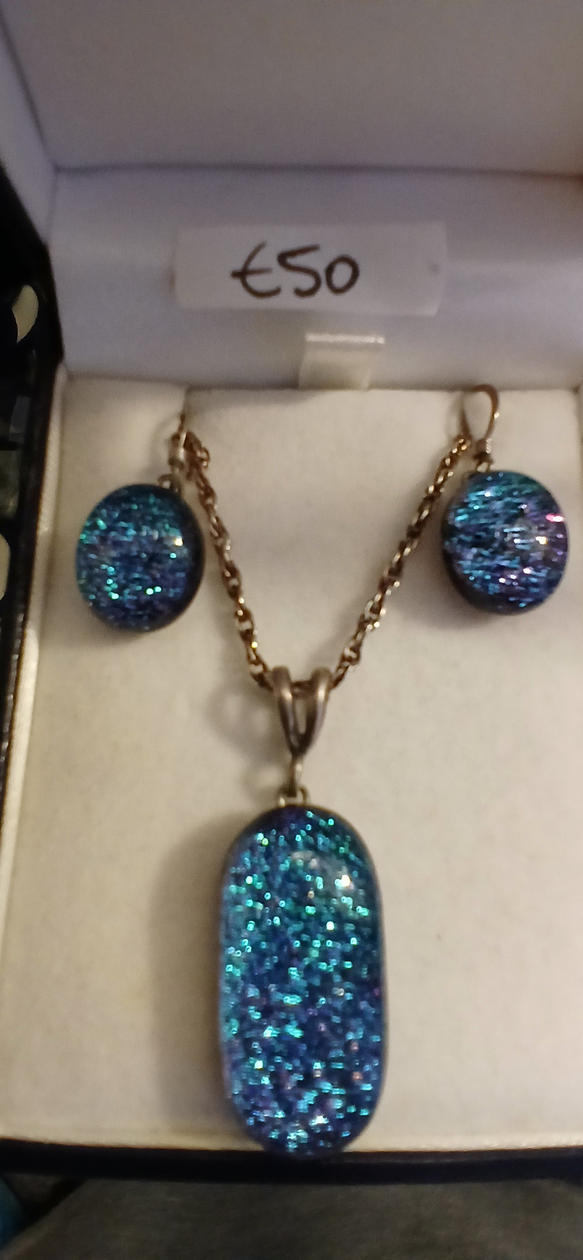 Experience the mesmerizing beauty of our Dichroic Glass Pendant with Earrings Set. This set is a perfect blend of style and elegance, featuring a unique color-shifting effect that adds a touch of magic to your outfit. The pendant and earrings are carefully crafted to ensure a perfect finish and a comfortable fit. Whether you're dressing up for a special occasion or adding a pop of colour to your everyday look, this set is sure to impress. hanging ear wires