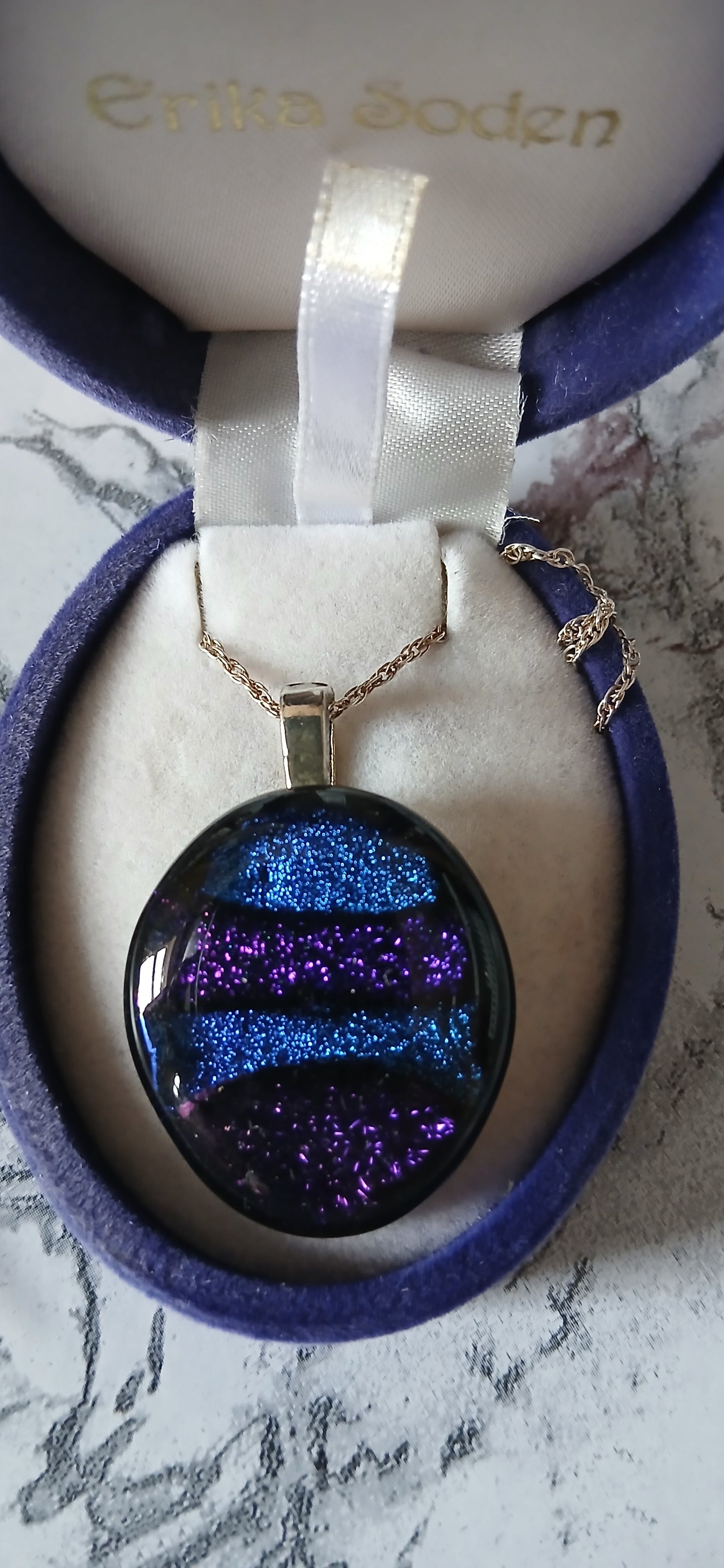 The combination of black, blue, and purple creates incredible versatility - this pendant complements everything from elegant evening wear to casual outfits that need a sophisticated focal point. The darker colour palette makes it particularly striking and perfect for those who prefer dramatic, statement pieces.