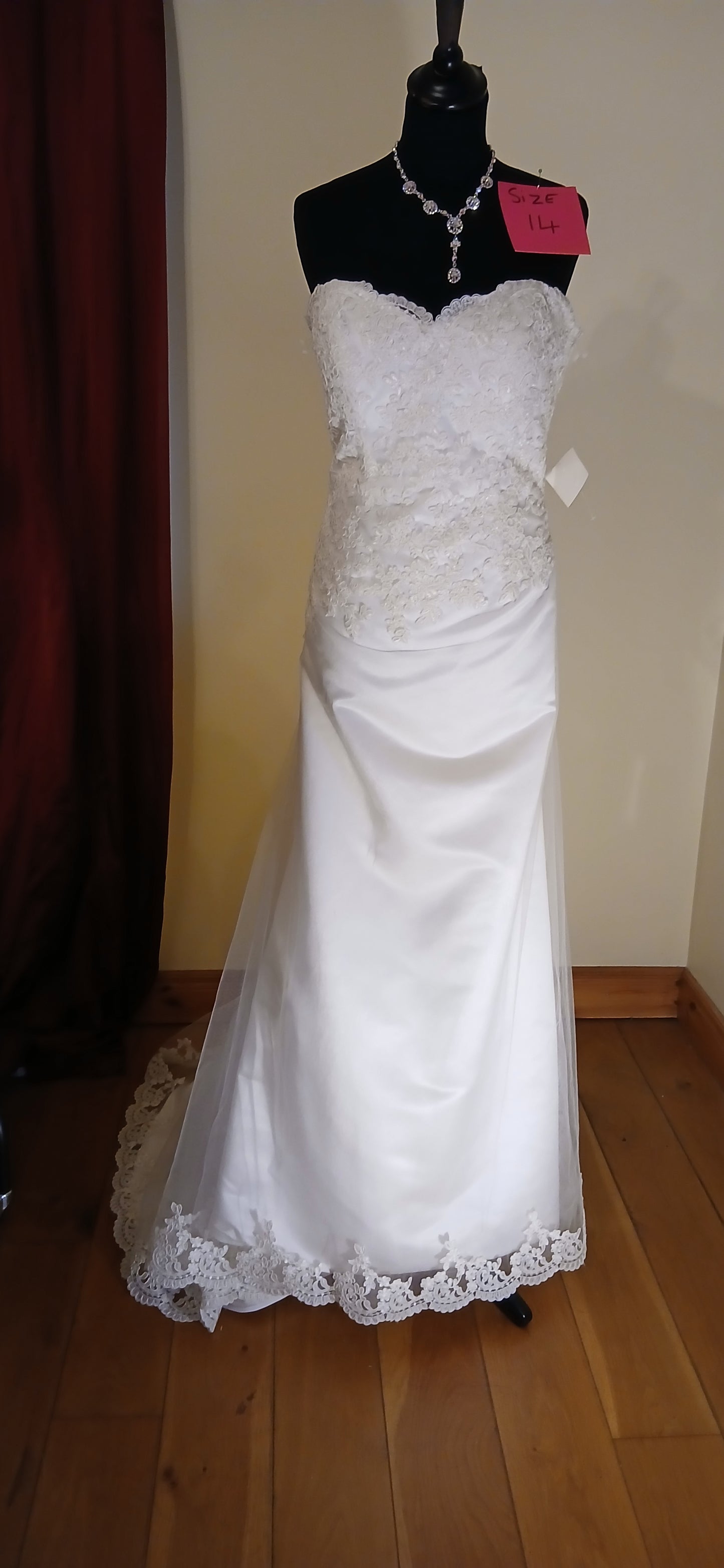 Size 14 ivory corset back lace and tulle dress with lace edge on train. This exquisite wedding dress features a delicate balance of lace and tulle, creating a romantic and ethereal look. The corset back adds a touch of elegance and sophistication, making it a perfect choice for any bride-to-be.