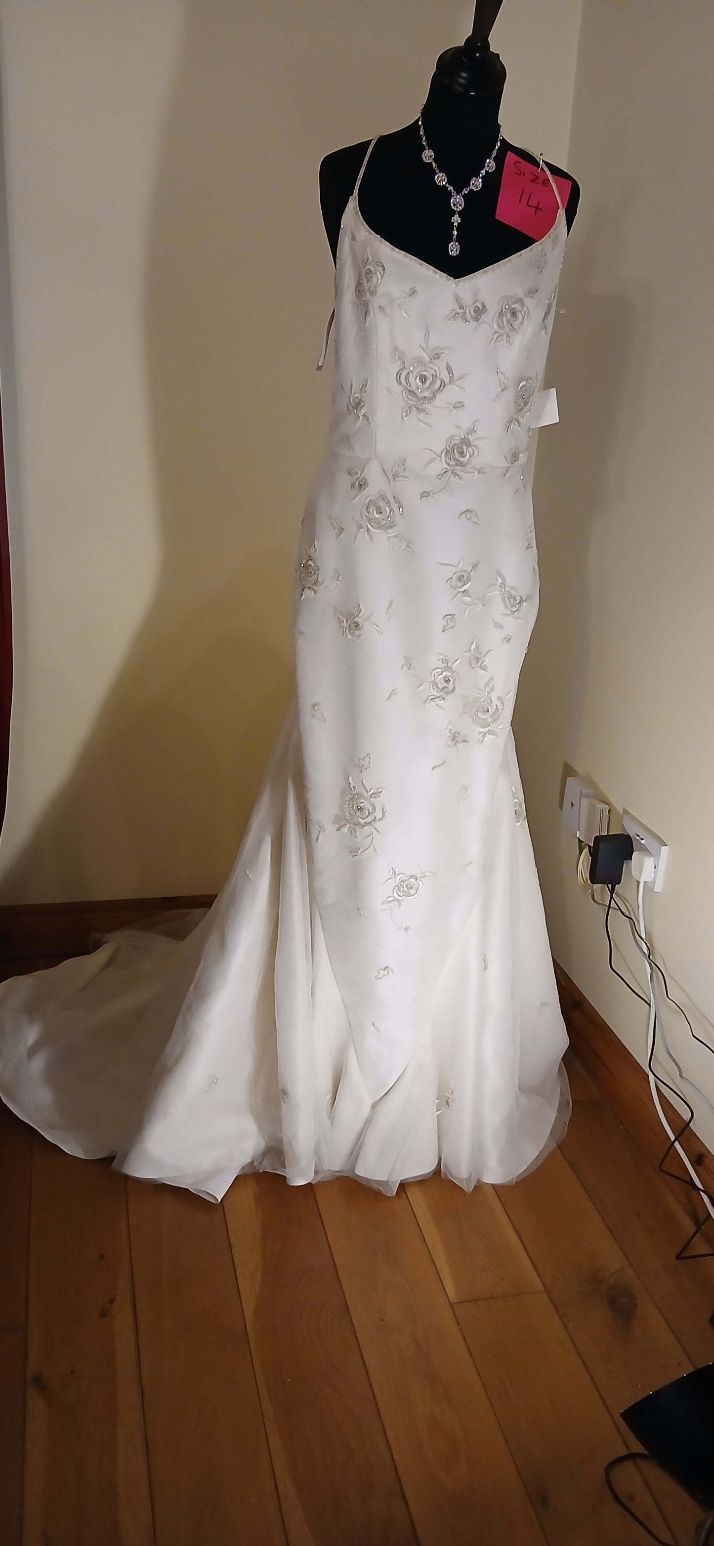 Fitted ivory gold dress size 14 with train. This stunning wedding dress features intricate gold floral motifs, adding a touch of elegance and sophistication to your special day.