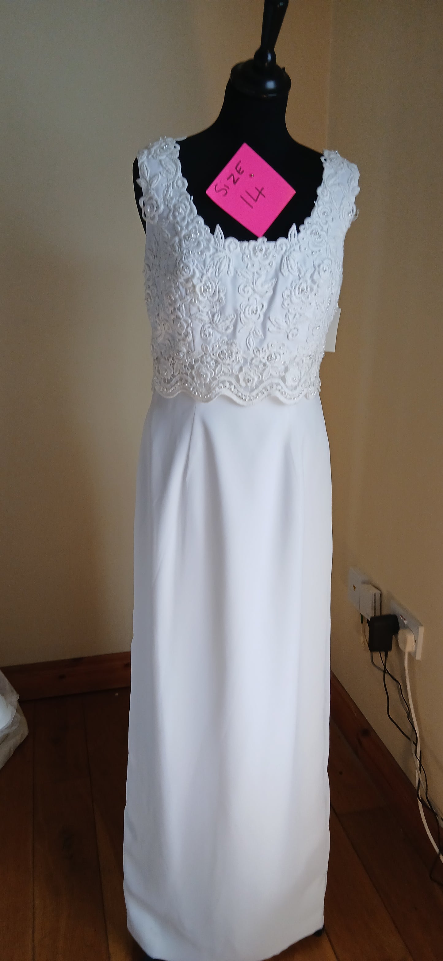 This beautiful wedding dress is a size 14 and is a stunning shade of white. 