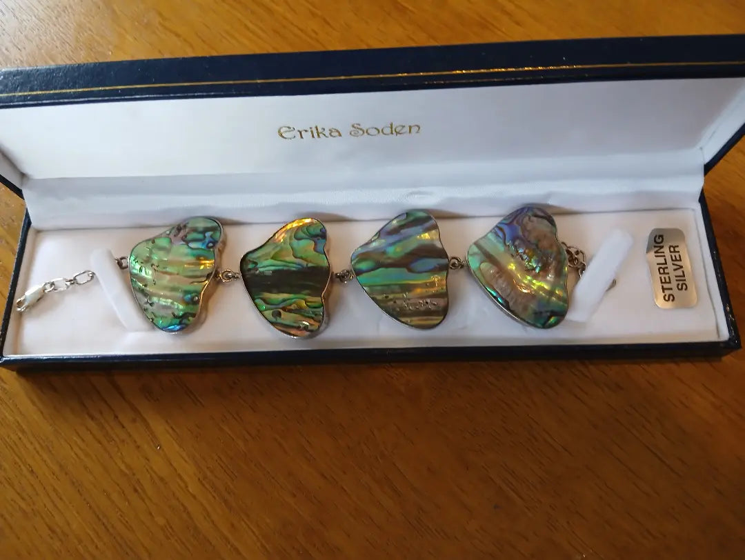Sterling silver chunky abalone bracelet featuring large iridescent abalone shell pieces in greens and blues with silver accents