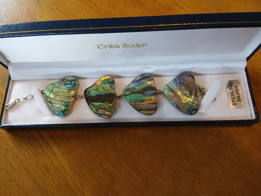 Sterling silver chunky abalone bracelet featuring large iridescent abalone shell pieces in greens and blues with silver accents