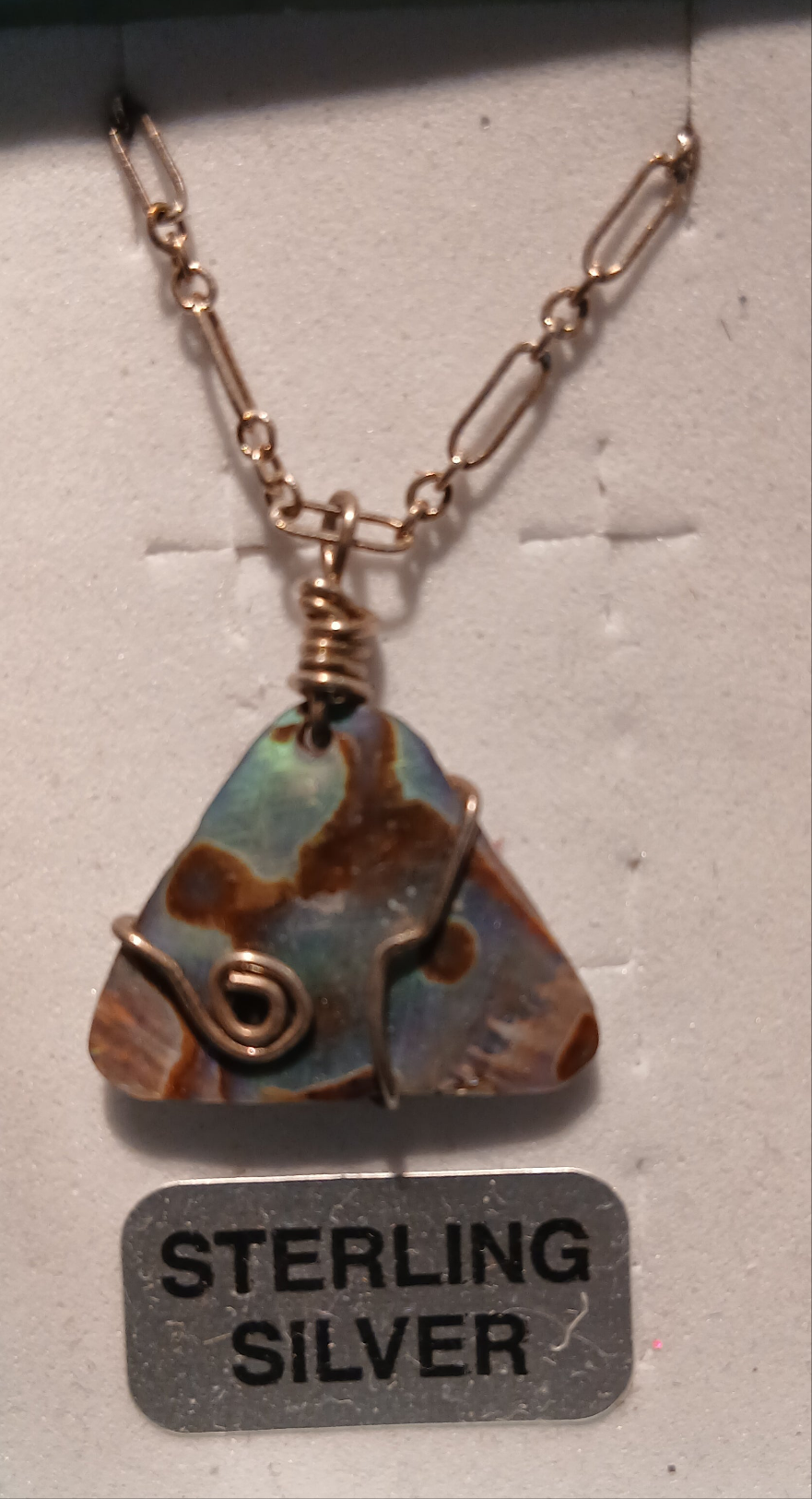 Dive into oceanic beauty with this mesmerizing Abalone Sterling Silver Necklace that captures the iridescent magic of the sea. The stunning abalone shell pendant displays nature's own artistry with its rainbow-like shimmer that shifts from deep blues and greens to silvery purples and golden hues as it catches the light.

Abalone shell is treasured for its unique mother-of-pearl luster that makes each piece completely one-of-a-kind. No two abalone shells are exactly alike, 