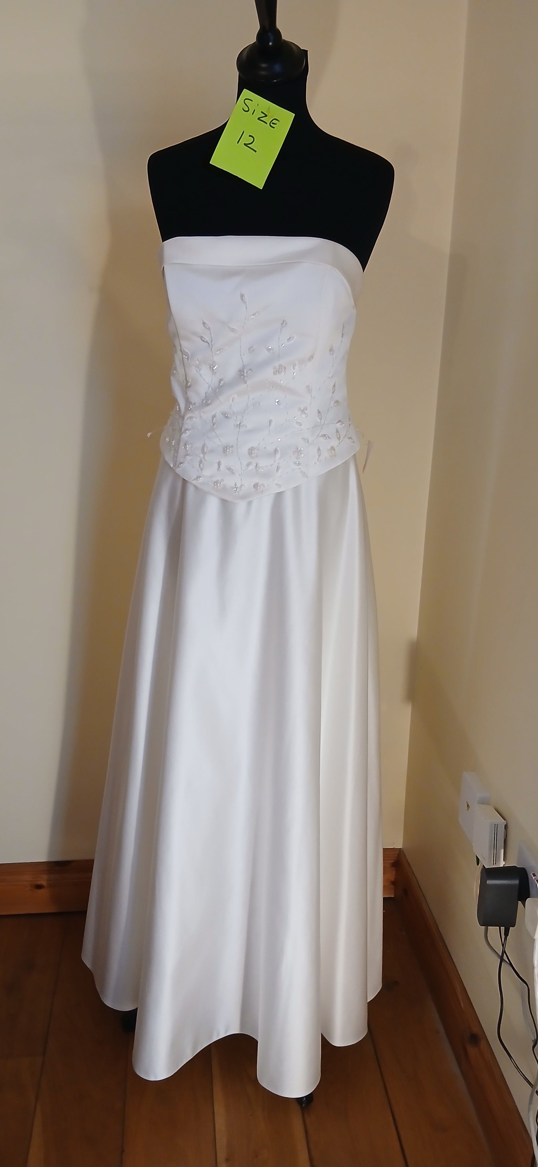  a size 12 in ivory. Made from high-quality satin,  features a corset back and no train.