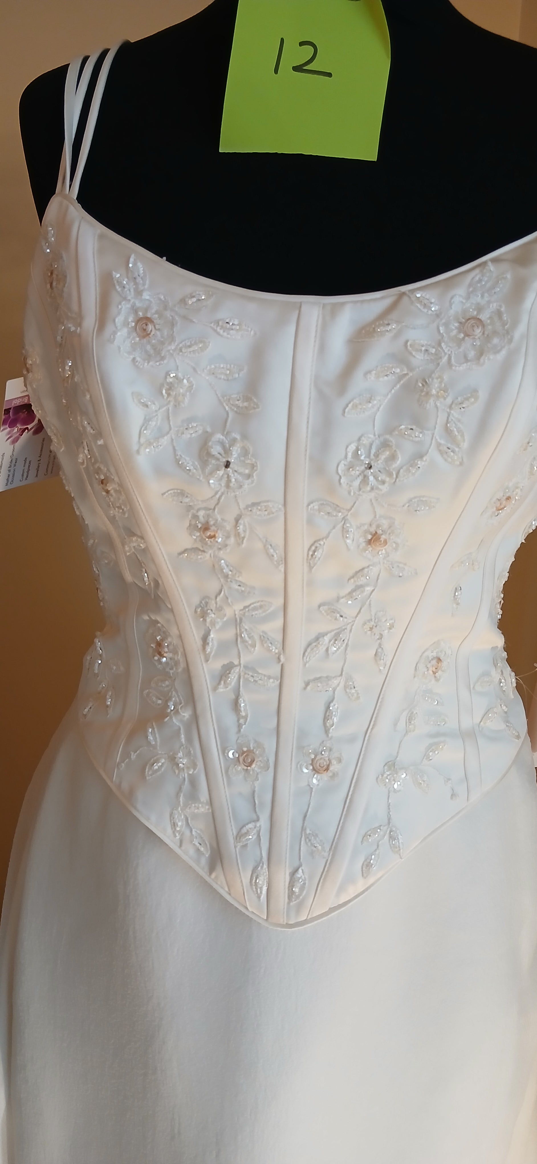 This exquisite wedding dress is a size 12 in elegant ivory. It features a detachable train,