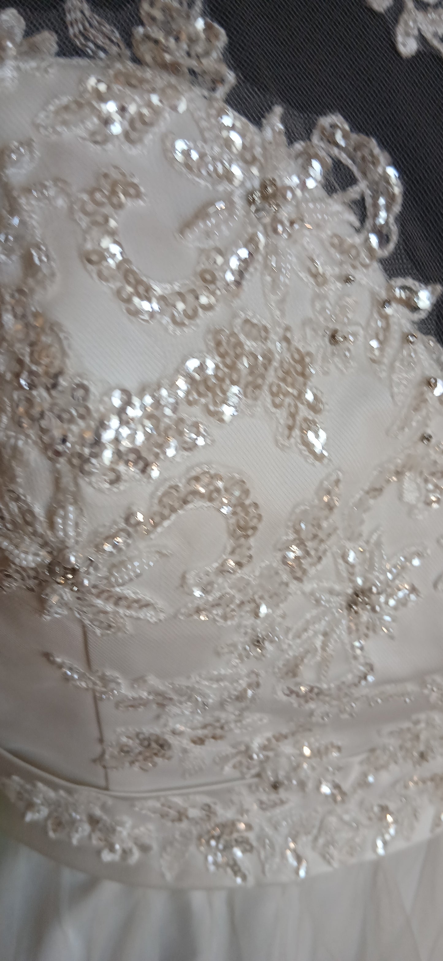 Close-up of a wedding dress with intricate beadwork and lace details.