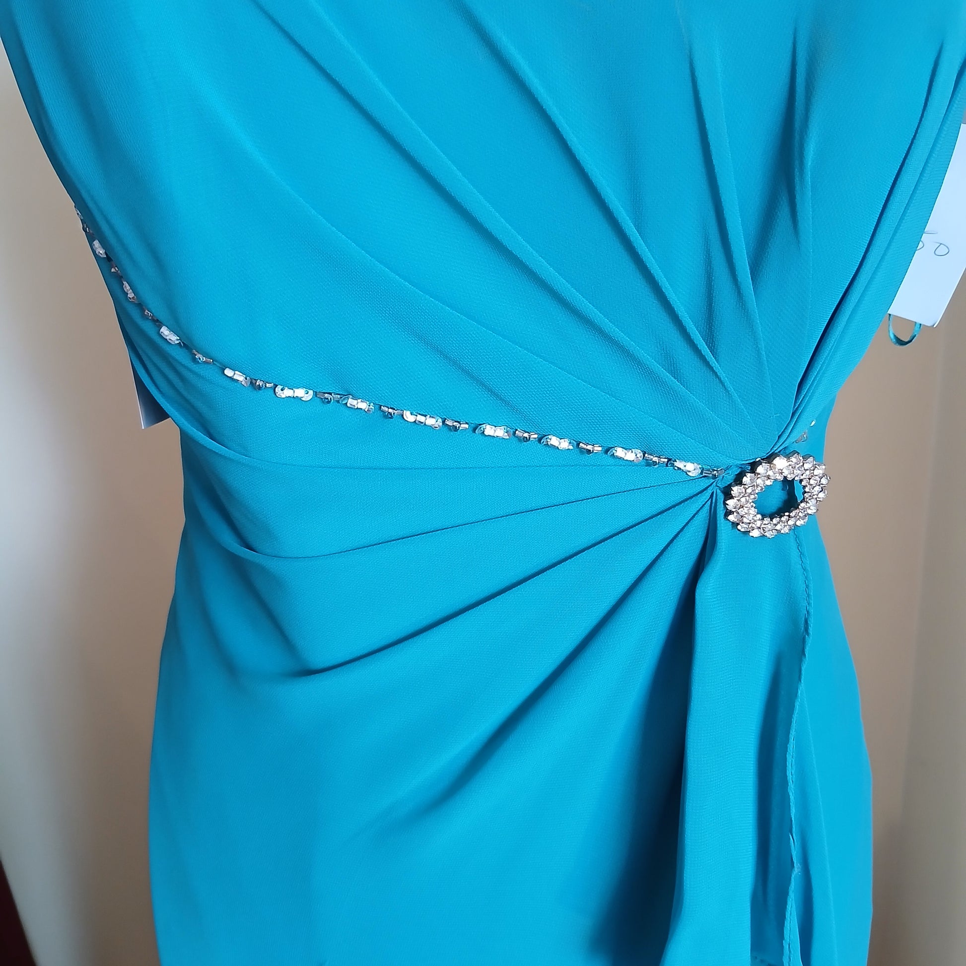 Close-up of a blue dress with a decorative embellishments.