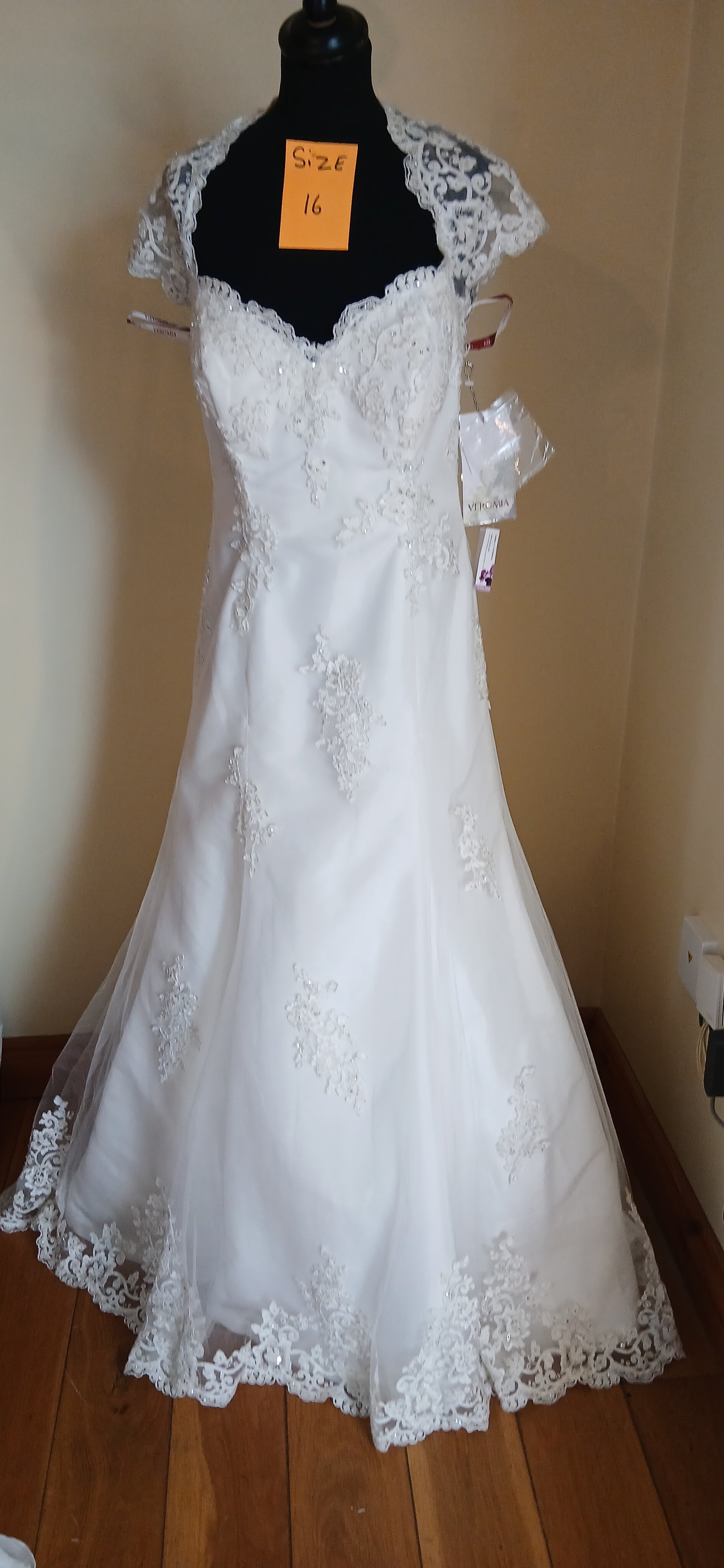  Wedding dress Isabelle, size 16. This exquisite ivory lace dress features cap sleeves, a sweetheart bust line, and a scalloped lace train. 