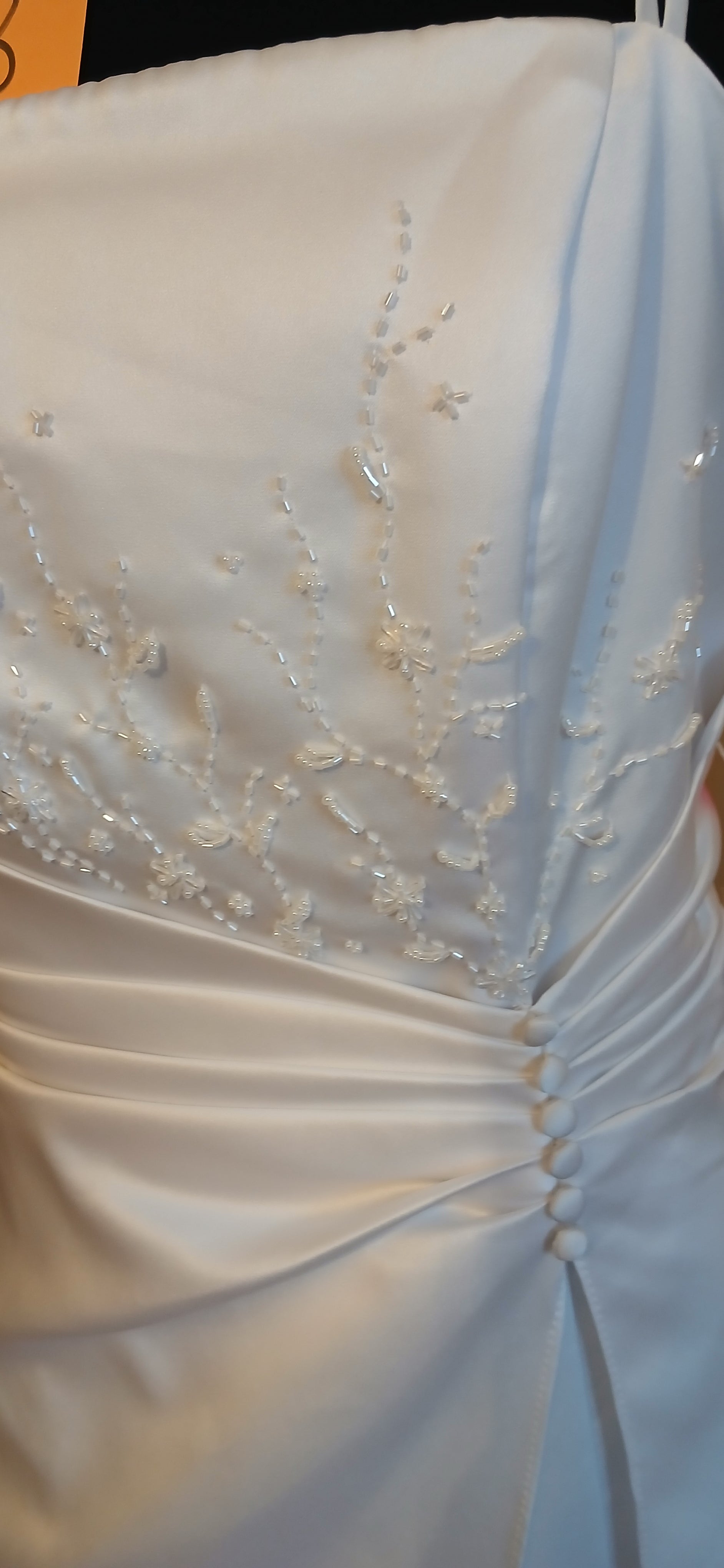 Close-up of a white wedding dress with intricate detailing