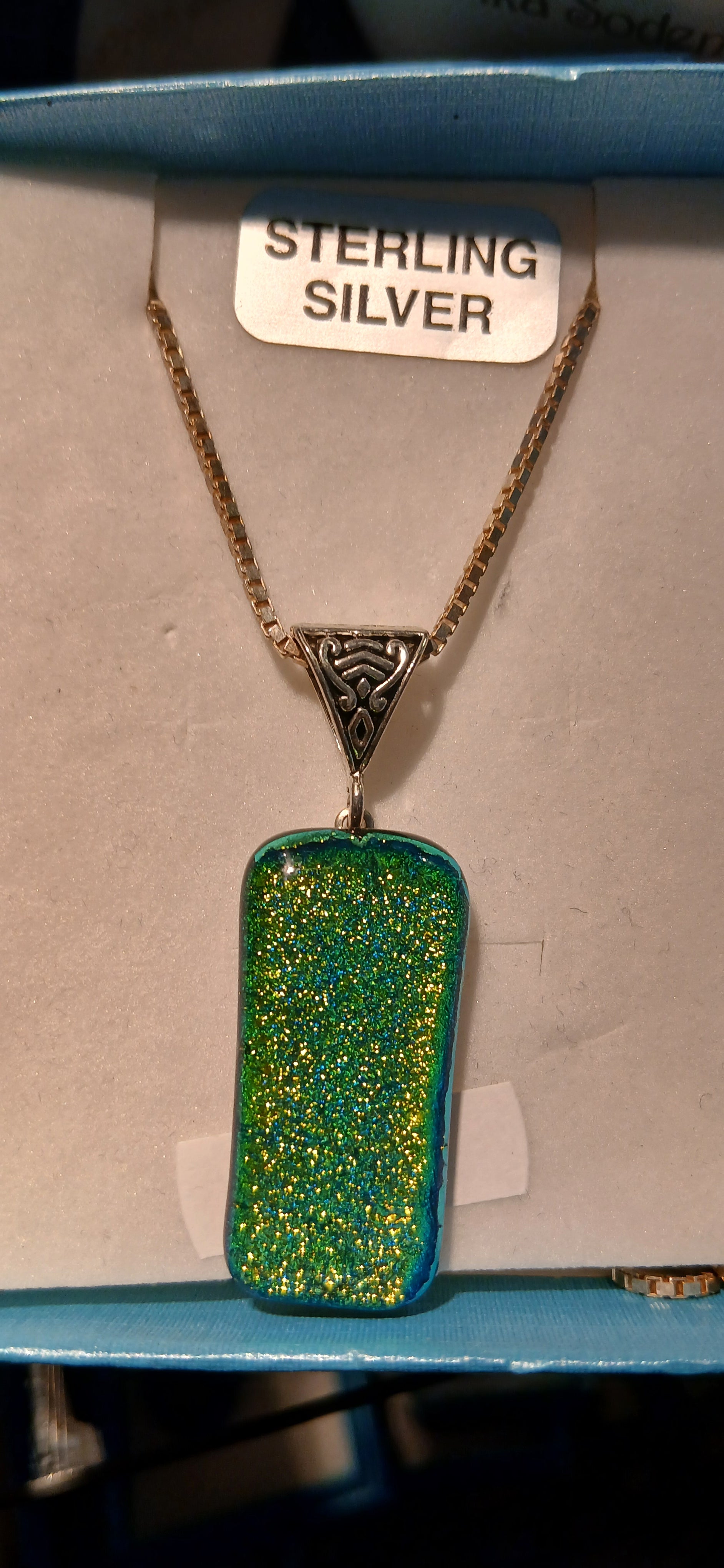Embrace the tranquil beauty of nature with this stunning Green Dichroic Glass Pendant that captures the essence of emerald forests and spring meadows. This exquisite handcrafted piece showcases mesmerizing shades of green that shift from deep forest tones to brilliant jade, creating a captivating display of color that changes with every angle and light.

The dichroic glass technique creates an almost magical effect 