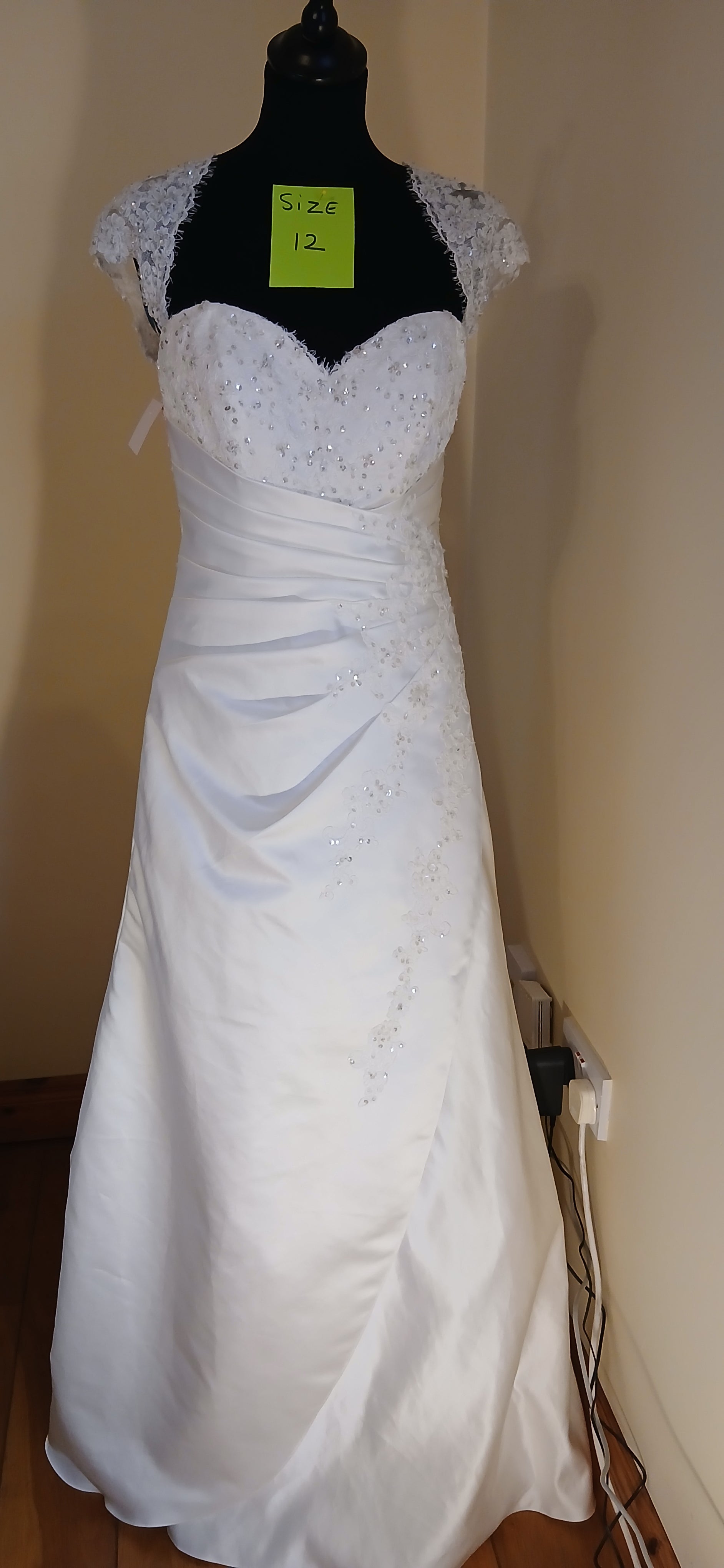 Experience the magic of your special day in our enchanting Wedding Dress. This size 12 ivory satin dress is a clearance sale item, available for €800. 