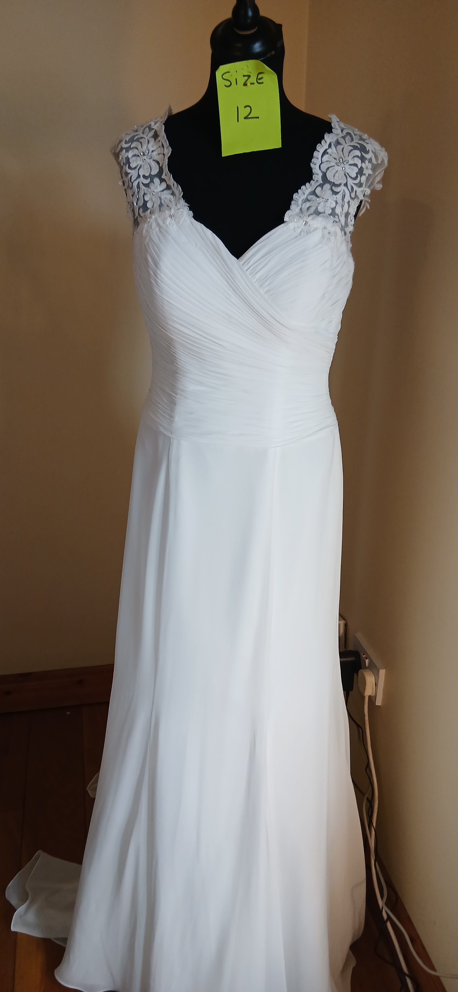 This lovely  lace wedding d dress is a size 12 in ivory. It's a perfect choice for any bride looking for a classic and elegant look on their special day.